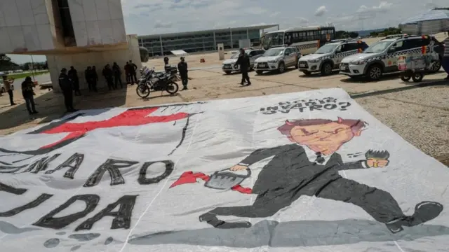 Bandeira com desenho de Bolsonaro ao lado de suástica nazista