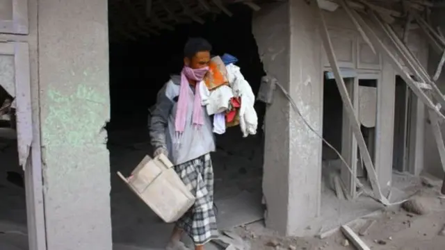 Seorang warga mengangkut barang yang bisa diselamatkan dari rumahnya yang hancur akibat erupsi gunung Semeru di desa Supiturang, Lumajang, Jawa Timur, Minggu (05/12).