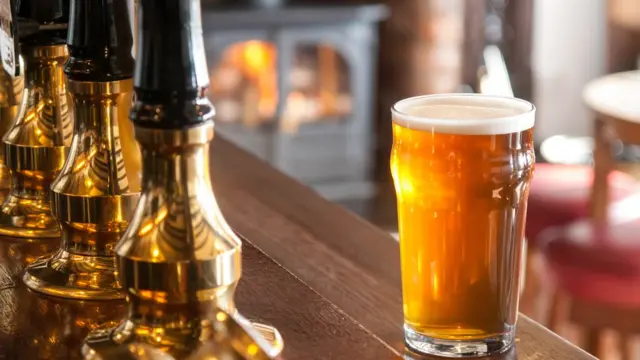 Стакан с пивом на стойке бара