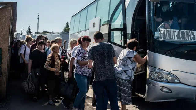 Pensionados suben a un autobús cerca de la línea del frente