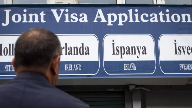 Vize ofisi önünde bekleyenbir adam