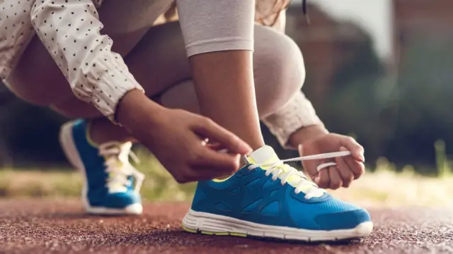 Joven atándose los cordones