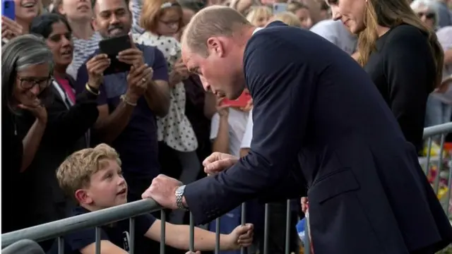 Le Prince William parle à un enfant devant le château de Windsor.
