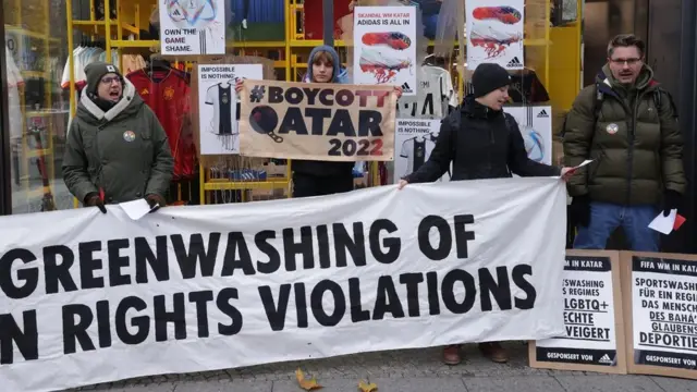 한 시위대가 베를린에서 FIFA의 주요 후원사인 아디다스 앞에 모여, 2022 월드컵에 인권 침해와 그린워싱이 있었다고 주장하고 있다