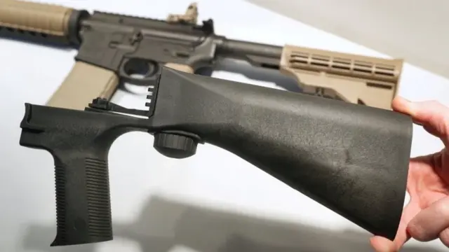 Un bump stock junto a un rifle