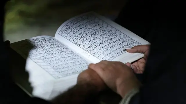 কোরআন পড়ছেন এক নারী