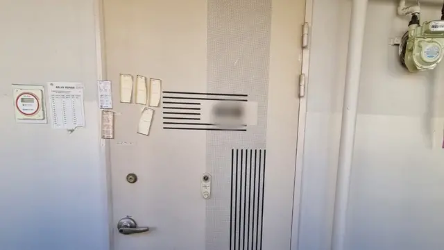 각종 고지 메모들이 붙어있는 대문이 닫혀있다