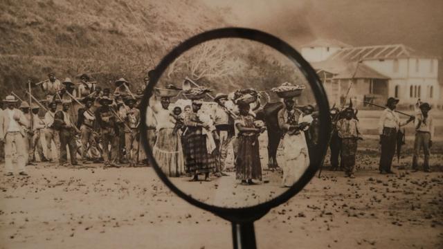 Lupa sobre foto histórica de escravos no Brasil. (Isabel Löfgren e Patricia Gouvêa/Modos de Olhar, série Mãe Preta/foto: Marc Ferrez)