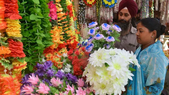Sikh couple looks at artificial garlands ahead of Diwali in Amritsar