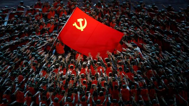 北京鸟巢中国共产党成立100周年纪念文艺晚会上上百名身穿军队救援工作服的舞蹈员做出支撑党旗姿势（28/6/2021）