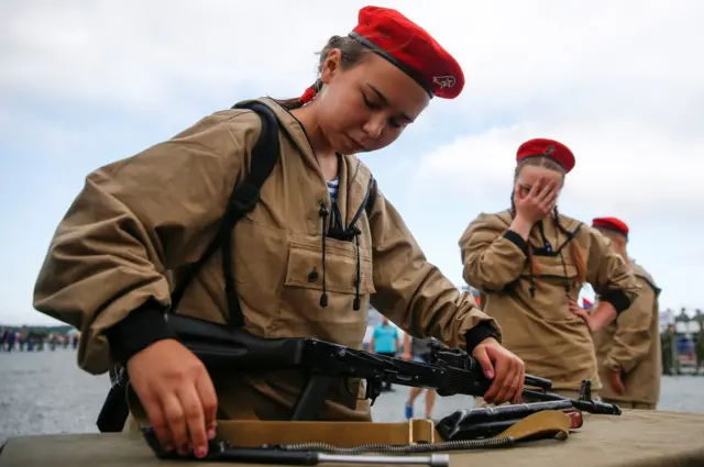 A girl in army wear concentrates on assembling a gun at the 2017 International Army Games.