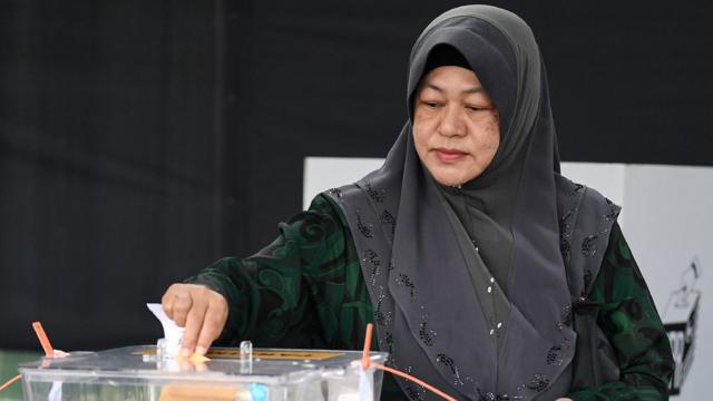 Женщина в хиджабе голосует