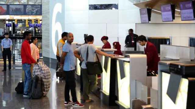 Katar'ın başkenti Doha'da yolcular uçağa binmeye çalışıyor