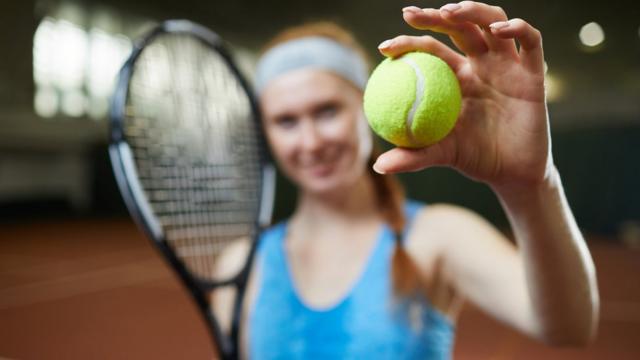 Tenista segurando bolaflamengo sportsbet iotênis na quadra