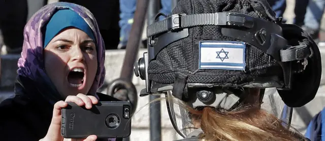 A Palestinian woman shouting in front of a female Israeli soldier at a protest