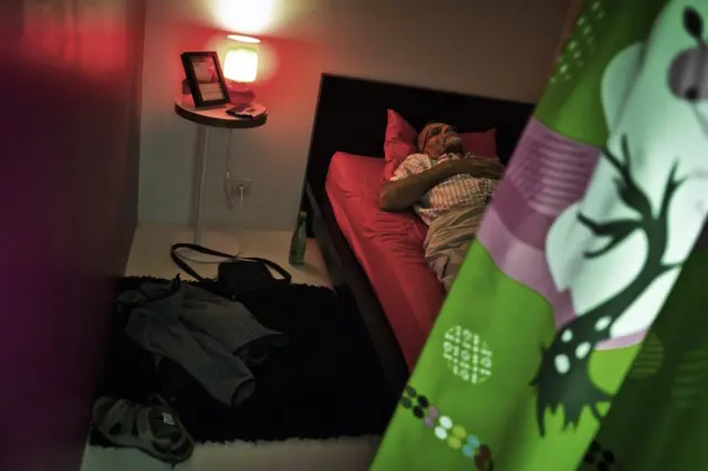 Hombre echándose una siesta en un local preparado para ello.