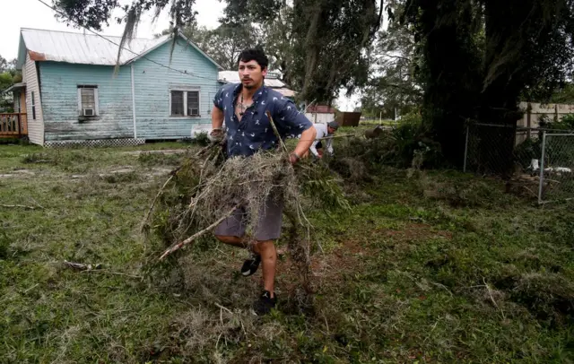 José Lobato (izquierda) y su hermano Tony Lovato recogen ramas y escombros dejados por Irma en su casa de Bowling Green, Florida, Estados Unidos, el 11 de septiembre.
