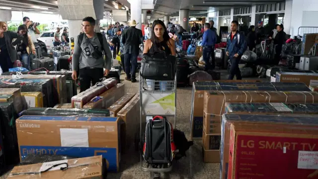 Em terminal, médicos cubanos carregam malas e pacotesjogo do foguete betviagem