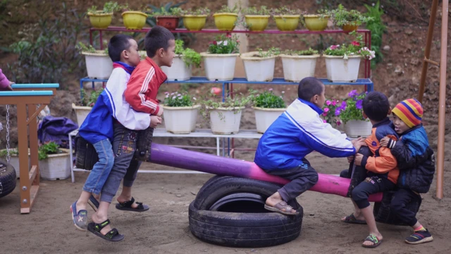 Vietnamese boys play on a see-saw.