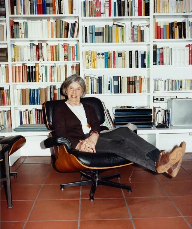 Anneliese sentada en una biblioteca