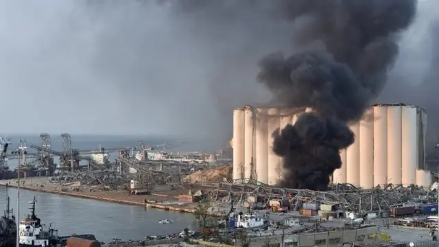Destrozo y humareda en el puerto de Beirut donde ocurrió la explosión.