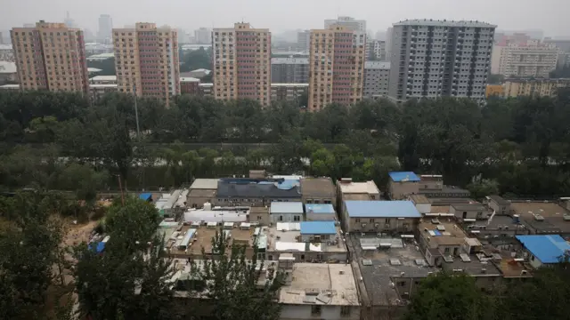 Edificios altos y modernos en el fondo y construcciones sencillas en primer plano.