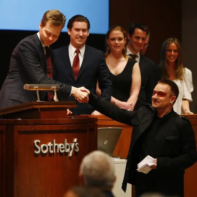 2008年，巴克的拍卖会为波诺（Bono）的艾滋病慈善基金会RED募集了4200万美元后，这名歌手握住他的手。巴克与赫斯特的合作从未间断 | Getty Images