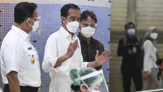 Presiden Joko Widodo (tengah) didampingi Menteri Kesehatan Budi Gunadi Sadikin (kanan) berbincang dengan Gubernur DKI Jakarta Anies Baswedan saat meninjau vaksinasi COVID-19 massal bagi pedagang di Pasar Tanah Abang Blok A, Jakarta, Rabu (17/02).