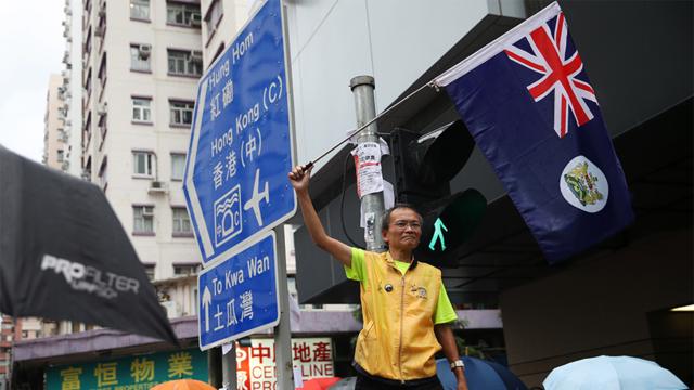 香港九龙参与“光复红土”游行一名年长男子挥舞旧英属香港旗帜（17/8/2019）
