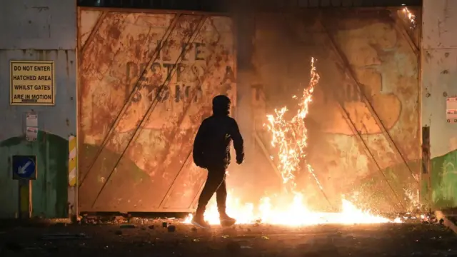 Joven ante un incendio en las protestas en Irlanda del Norte