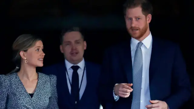 el príncipe Harry con dos asesores de comunicación