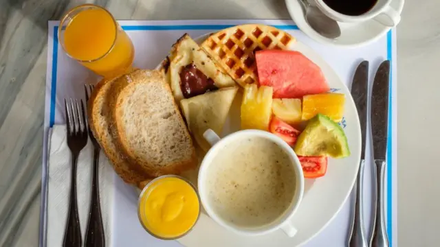 Petit-déjeuner sain avec des fruits frais et du porridge avec une tasse de café