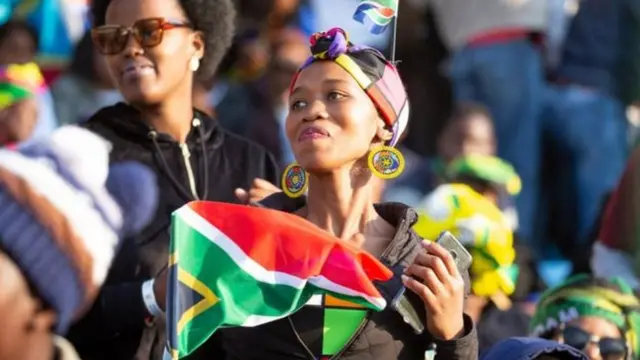 Hari imbaga izunguza ibendera ry'Afurika y'epfo ubwo Perezida Ramaphosa yarahizwaga