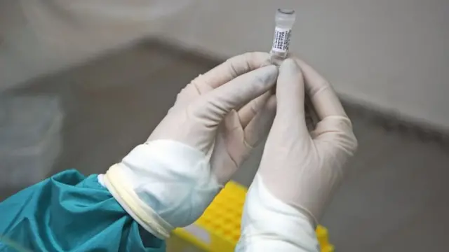 የምርመራ መርፌ የያዘ ባለሙያ እጅ