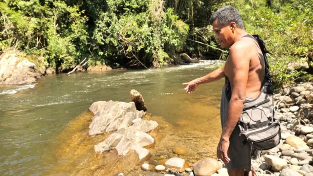 Mawi menunjuk batu di mana harimau membunuh manusia.