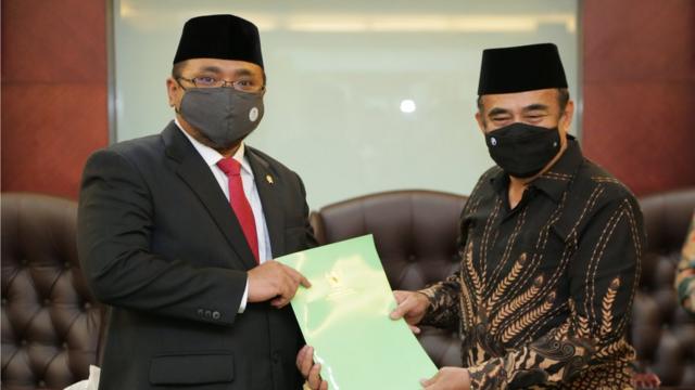 Menteri Agama Yaqut Cholil Qoumas (kiri) bertukar naskah dengan mantan Menteri Agama Fachrul Razi saat serah terima jabatan di Kantor Kemenag, Jakarta, Rabu (23/12)