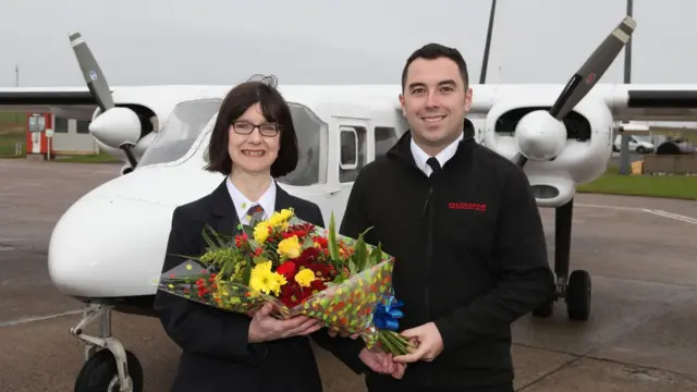 Piloto oferece flores a passageira