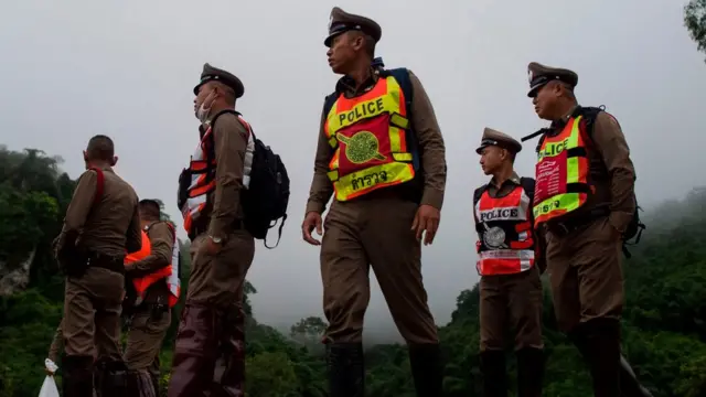 Thai police guard a road leading to the Tham Luang cave