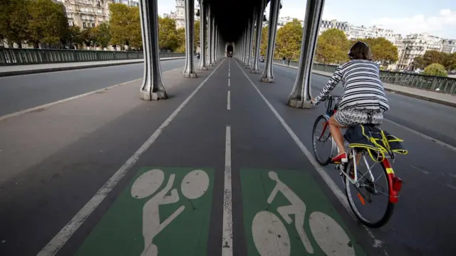 A woman cycles in Paris