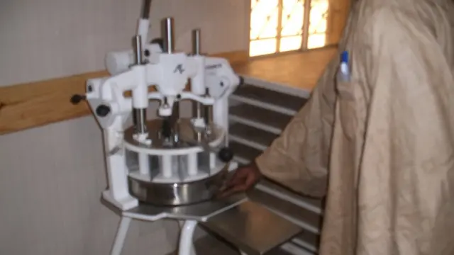 Un détenu manie une partageuse, l'outil servant à couper la farine lors de la fabrication du pain.