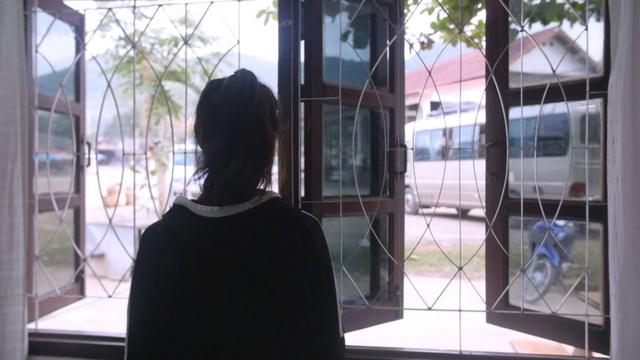 Jiyun looks out of a window during a rest stop on their long journey to the South Korean embassy