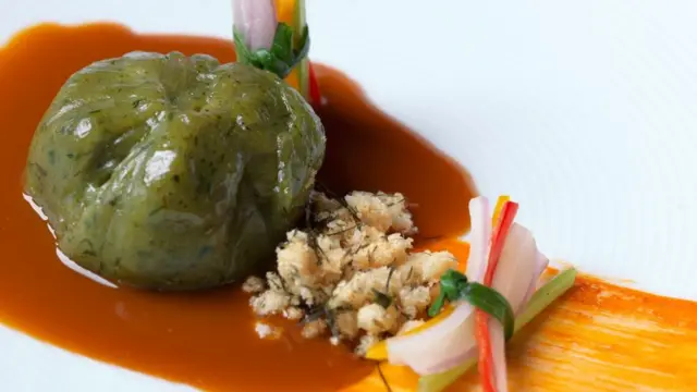 Plato creación de Mitsuharu tiene filamentos de cebolla y pimiento, una suerte de puré verde y una salsa.