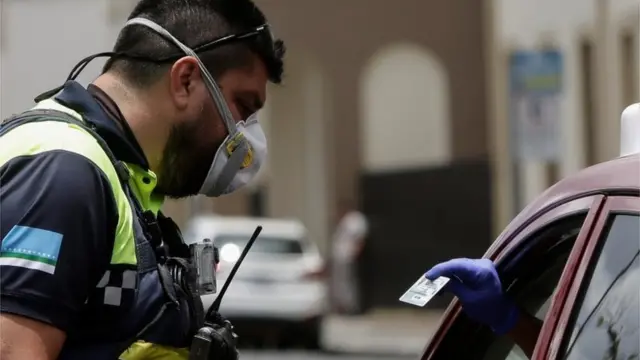 Un policía inspeccionando a un automovilista