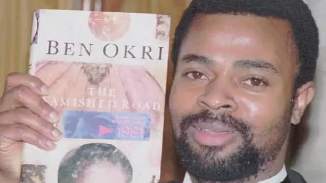 Ben Okri con una copia de "The famished road"