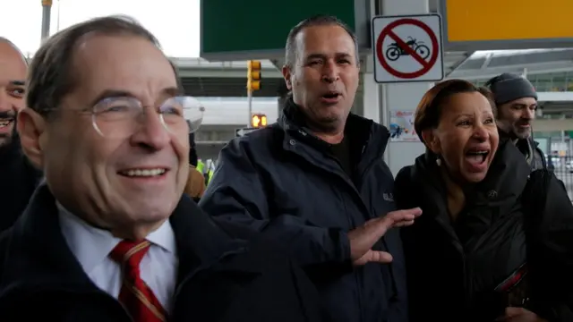 یک مهاجر عراقی پس از آزادی از بازداشت موقت در فرودگاه جان اف کندی در میان دو نماینده کنگره امریکا