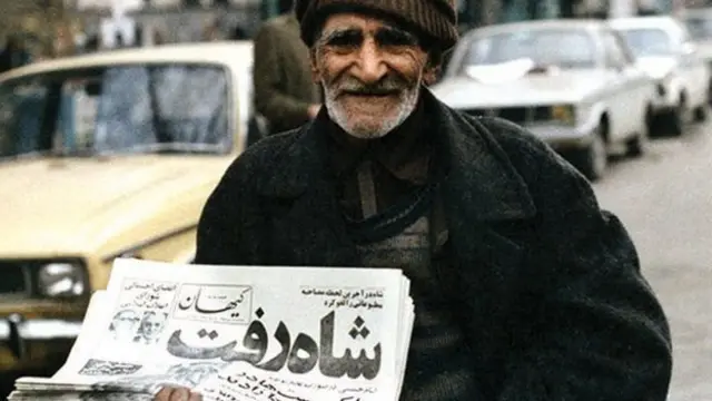 پیرمردی که روزنامه شاه رفت را در دست دارد