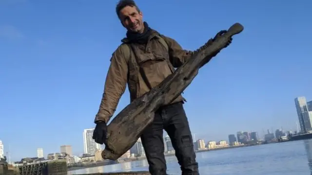 مايلز تافيرنير يحمل قطعة خردة على الشاطئ