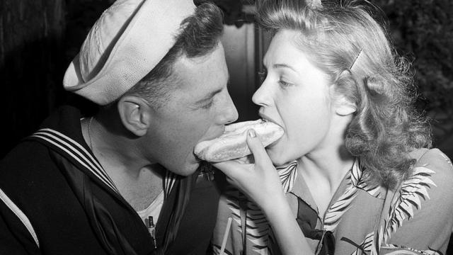 На Кони-Айленде моряк и его девушка вместе едят один хот-дог