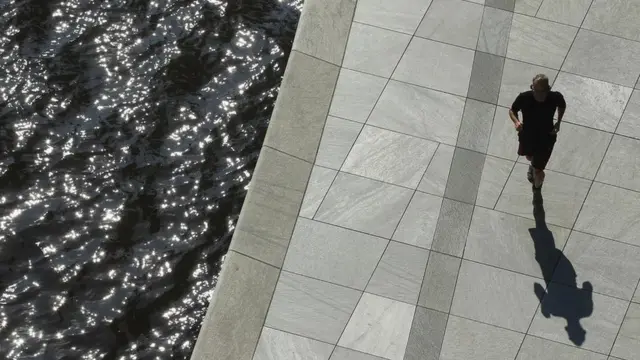 一位慢跑者沿着德国柏林联邦议会附近的施普雷河跑步。