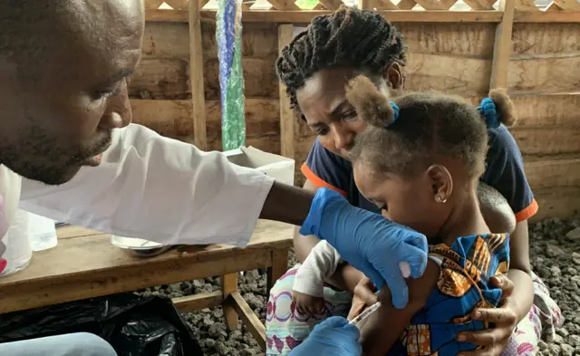 A handout photo made available by the World Health Organization (WHO) shows a child receiving a vaccination for measles at a health center in Goma